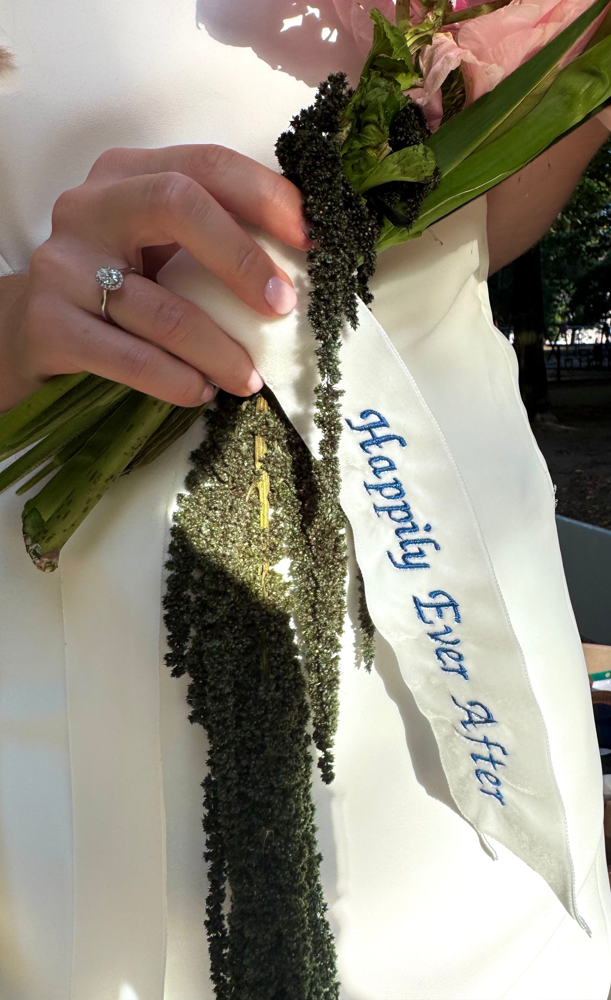 Bukiet owinięty aksamitną wstążką z napisem „Happily Ever After”.