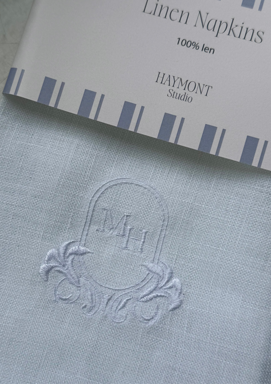 White linen napkin with crest and initials - zoomed in