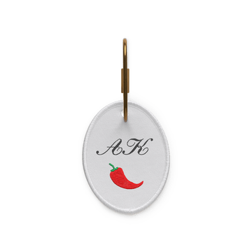 A key ring with the initials “AK” and a chili pepper icon